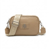 Bolso cruzado beige minimalista con placa metálica