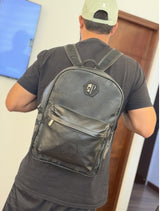 Mochila negra mate con placas metálicas y bolsillo frontal